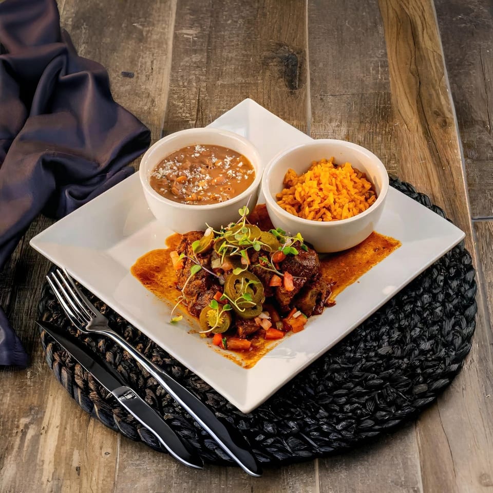 El Patio's Mexican dish with beef, jalapeños, beans, and rice on a white plate.